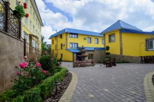 a courtyard with two yellow buildings and flowers at Argo Premium in Lviv