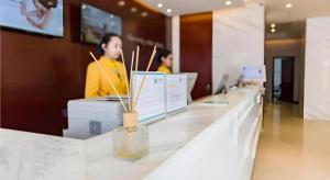a counter in a store with two people working on computers at City Comfort Inn Nanchang Shuanggang Metro Station Finance University in Nanchang