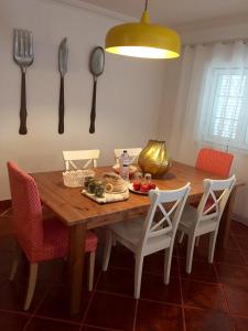 a dining room table with chairs and utensils on the wall at Monte do Espadanal in Cercal