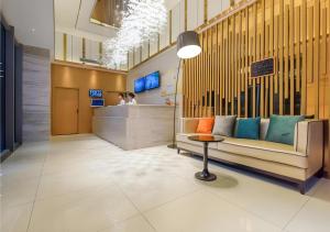 un hall avec un banc et une table dans un bâtiment dans l'établissement City Comfort Inn Guiyang Financial City, à Guiyang