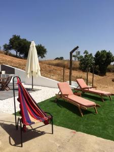two lounge chairs and an umbrella and a hammock at Monte do Espadanal in Cercal