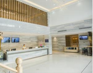 a lobby with a woman sitting at a reception desk at City Comfort Inn Dongguan Zhongtang in Guangzhou