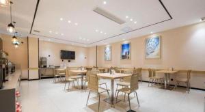 a restaurant with tables and chairs in a room at City Comfort Inn Huangshi Bei Station in Huangshi