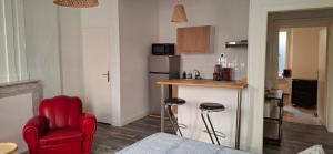 a small kitchen with a red chair and a counter at Studio au cœur de Sommières in Sommières +4 photos