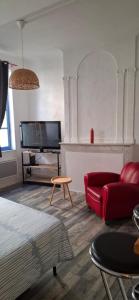 a living room with a red couch and a tv at Studio au cœur de Sommières in Sommières