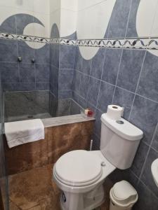 a bathroom with a toilet and a shower at Casa blanca alojamientos in Manta +19 photos