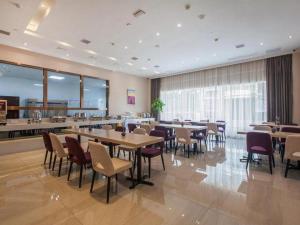 a restaurant with tables and chairs in a room at Lavande Hotels· Suizhou Wenfeng in Suizhou