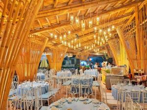 a banquet hall with white tables and chairs at SPRING GARDEN HOTEL LK in Long Khanh