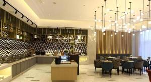 a lobby with a restaurant with tables and chairs at Magnotel Hengshui Lake Jizhou Middle School in Hengshui