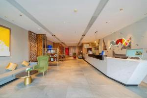 a living room with a couch and a table at Borrman Hotel Zhanjiang Wuchuan Jinsha Plaza in Zhanjiang