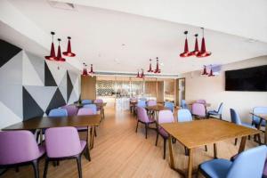 a dining room with tables and purple chairs at Borrman Hotel Zhanjiang Wuchuan Jinsha Plaza in Zhanjiang