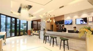 two people sitting at a bar in a hotel lobby at City Comfort Inn Qingyuan City Plaza Hefu Dongcheng in Qingyuan