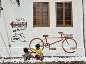 two children sitting in front of a bike on a building at HB01 テントと芝生が広がるお部屋 小田原港3分 8名可 箱根板橋駅徒歩8分 早川駅徒歩7分 Tent and lawn room Odawara Port 3 minutes 8 people Hakone Itabashi Station 8 minutes on foot Hayakawa Station 7 minutes on foot in Odawara