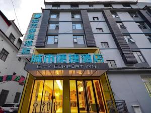 麗江市にあるCity Comfort Inn Lijiang Ancient Townの「シティ・カレンシー・イン」と書かれた看板のある建物