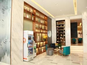 a lobby with a refrigerator and a table and chairs at Magnotel Hotel Xiamen North Station Binhai in Xiamen