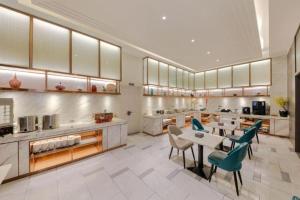 a large kitchen with a table and chairs at Magnotel Hotel Xiamen North Station Binhai in Xiamen