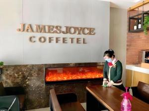 a woman with a face mask standing in a restaurant at James Joyce Coffetel Beijing Tongzhou Guoyuan Metro Station in Beijing