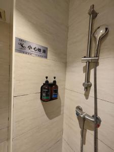 ein Badezimmer mit Dusche und zwei Flaschen Seife in der Unterkunft Sainan Hotel, Guangzhou Zhongda Lujiang Subway Station Branch in Guangzhou