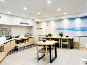 a cafeteria with tables and chairs and a large painting on the wall at Green Tree Inn Express Jiangsu Taizhou Xinghua RT-Mart in Xinghua