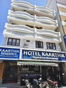 a hotel karachi with motorcycles parked in front of it at Kaarthik Residency in Puducherry