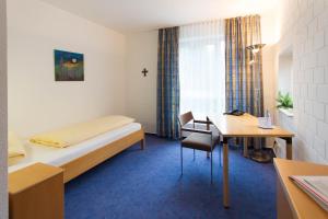 a hotel room with a bed and a desk and a table at Bergkloster Bestwig in Bestwig +33 photos