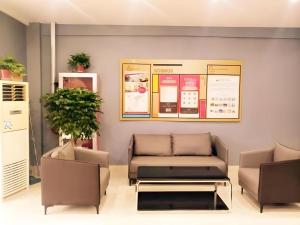 a living room with a couch and a table at Shell Hotel Jiangsu Taizhou Hailing District Taizhou Avenue in Sixiang