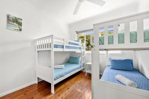 a bedroom with two bunk beds and a window at Barronstown - Pet Friendly with Fire Pit in Callala Beach