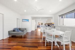 a dining room and living room with a table and chairs at Barronstown - Pet Friendly with Fire Pit in Callala Beach