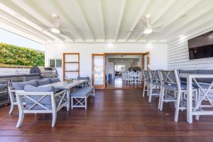 a dining room with chairs and tables and a ceiling at Barronstown - Pet Friendly with Fire Pit in Callala Beach