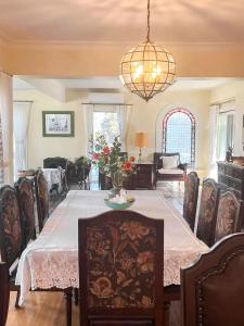 una sala da pranzo con tavolo, sedie e lampadario di Serene & Classic Family Retreat by the Yarra a Warrandyte