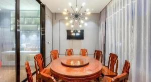 a dining room with a wooden table and chairs at Echarm Hotel Torch Development Zone Zhongshan Station in Zhongshan +140 photos