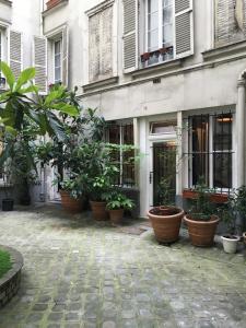 a group of potted plants sitting outside of a building at Maison Marais in Paris
