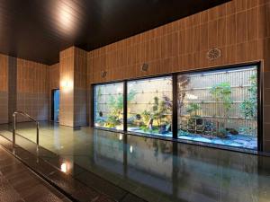 三沢市にあるホテルルートインＧｒａｎｄ三沢－ＥＡＳＴ　ＣＯＵＲＴ－の建物内の水族館付きスイミングプール