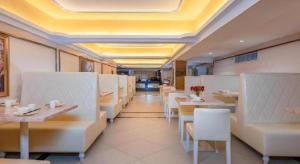 a restaurant with white tables and white chairs at Vienna Hotel Jiangxi Ji'an Jinggangshan in Jinggangshanzonghekenzhichang