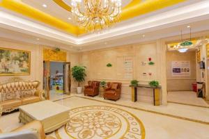 - un salon avec un lustre, un canapé et des chaises dans l'établissement Vienna Hotel Hunan Hengyang Leiyang, à Leiyang