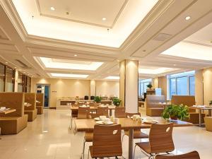 a restaurant with tables and chairs and a cafeteria at Vienna Hotel Shandong Qufu Sankong Landscape in Jining