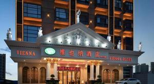 a building with a sign in front of it at Vienna Hotel Guangdong Zhaoqing Sihui Tianguangxu in Zhaoqing