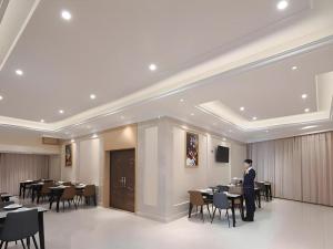 un hombre parado en una mesa en un comedor en Vienna Hotel Jiangsu Kunshan Qiandeng Town, en Suzhou