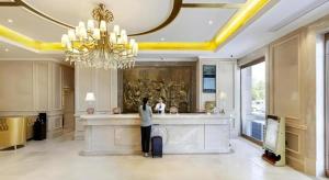 a woman standing at a counter in a hotel lobby at Vienna Hotel Jiangxi Shangrao High-Speed Railway Station in Shangrao +63 photos
