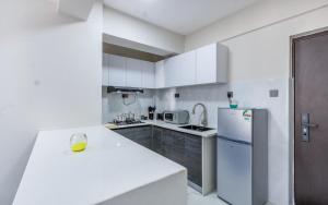 a kitchen with white cabinets and a white refrigerator at Yaya suites in Nairobi +10 photos