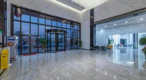 an empty lobby with a large glass door in a building at Green Tree Inn Zhejiang Ningbo Yuyao Haijixincheng Wholesales Market in Ningbo