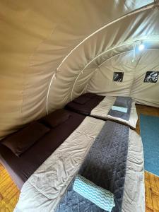 a bed in a tent with the door open at Dieng glamping syari'ah in Dieng +37 photos