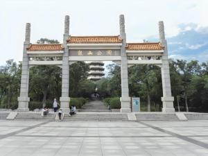 a large arch in a park with people sitting under it at GreenTree Inn Express Hefei City Bus Station in Feicheng