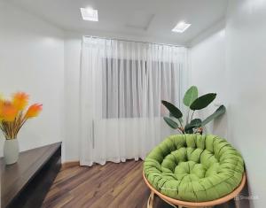 - Silla verde en la sala de estar con ventana en Moon Hotel Apt 3 Pham Tuan Tai, en Hanói