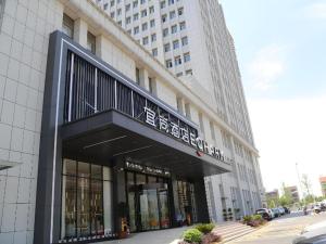 a building with a sign on the front of it at Echarm Hotel Huanggang Tuanfeng Administration Service Center in Luotian