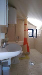 Un baño con lavabo y cortina de ducha. en Apartments Iva i Marko, en Marina 45 fotos más