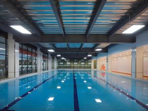 a large swimming pool with blue water at Vienna Hotel Hangzhou Jiubao Sijiqing Suanli Town in Hangzhou