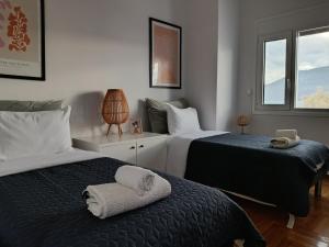 a bedroom with two beds and a window at Beach Retreat in town in Korinthos