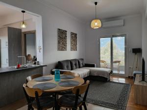 a living room with a table and a couch at Beach Retreat in town in Korinthos