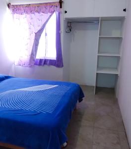 a bedroom with a blue bed and a window at Bienvenidos a la casa gris in Tolentino
